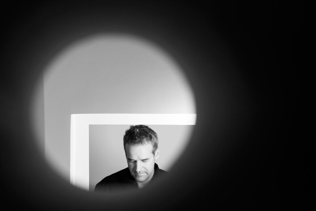 Künstlerportrait München: Galerist Stephan Stumpf fotografiert mit spannender Perspektive in seiner Galerie Störpunkt.