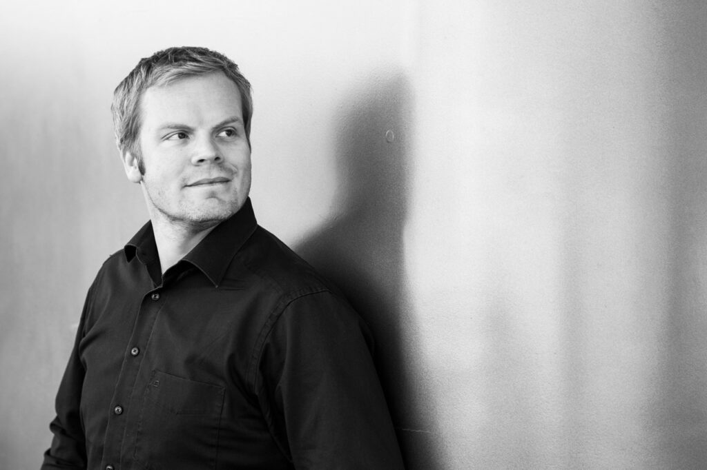 Outdoor Business Potrait in schwarz-weiss von Mann vor neutralem Hintergrund