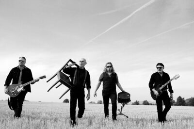 Cooles Bandfoto in Schwarz-weiß auf Stopplefeld. Musiker mit Instrumenten.