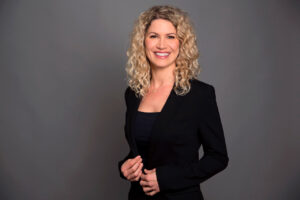 Halbportrait einer Frau vor grauem Hintergrund. Bewerbungsfoto für die Karriere aus dem Fotostudio München.