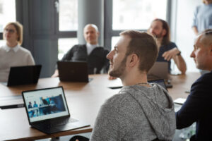 Moderne Corporate Fotografie von Team eines IT-Unternehmens bei der Besprechung in den modernen Büroräumlichkeiten.