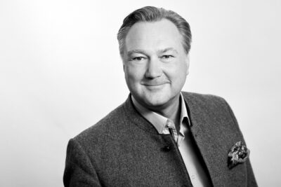 Professionelles Executive-Bewerbungsbild in schwarz-weiß von einem Manager im Fotostudio München, fotografiert vor hellem Hintergrund, mit Fokus auf Souveränität.