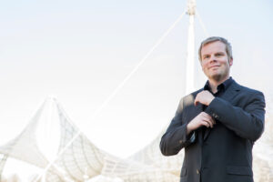 Professionelles Outdoor-Businessportrait von Steuerberater vor urbanem Hintergund.