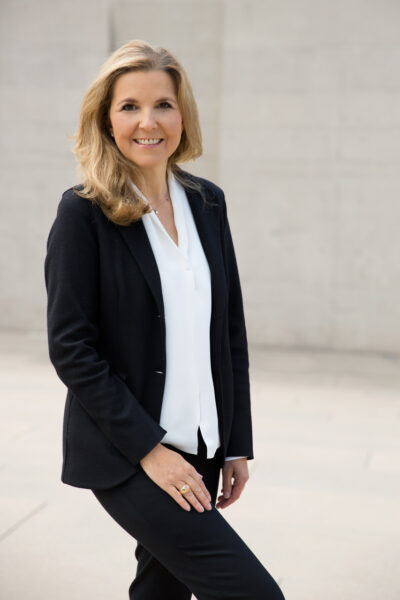 Starke Personal-Branding-Fotografie von Unternehmerin vor reduzierter Natursteinfassade optimal in Szene gesetzt.