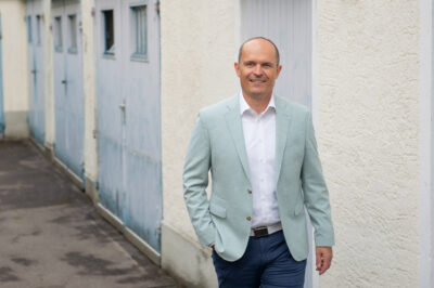 Personal-Branding-Fotografie: ein Unternehmer in Bewegung, im Hintergund ist dezent ein Innenhof in München zu sehen.