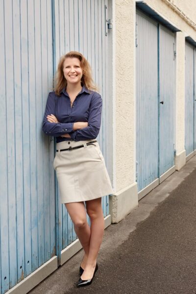 Professonelles Businessportrait einer Unternehmerin. Stilvolle Ganzkörperaufnahme in einem Innenhof in München.