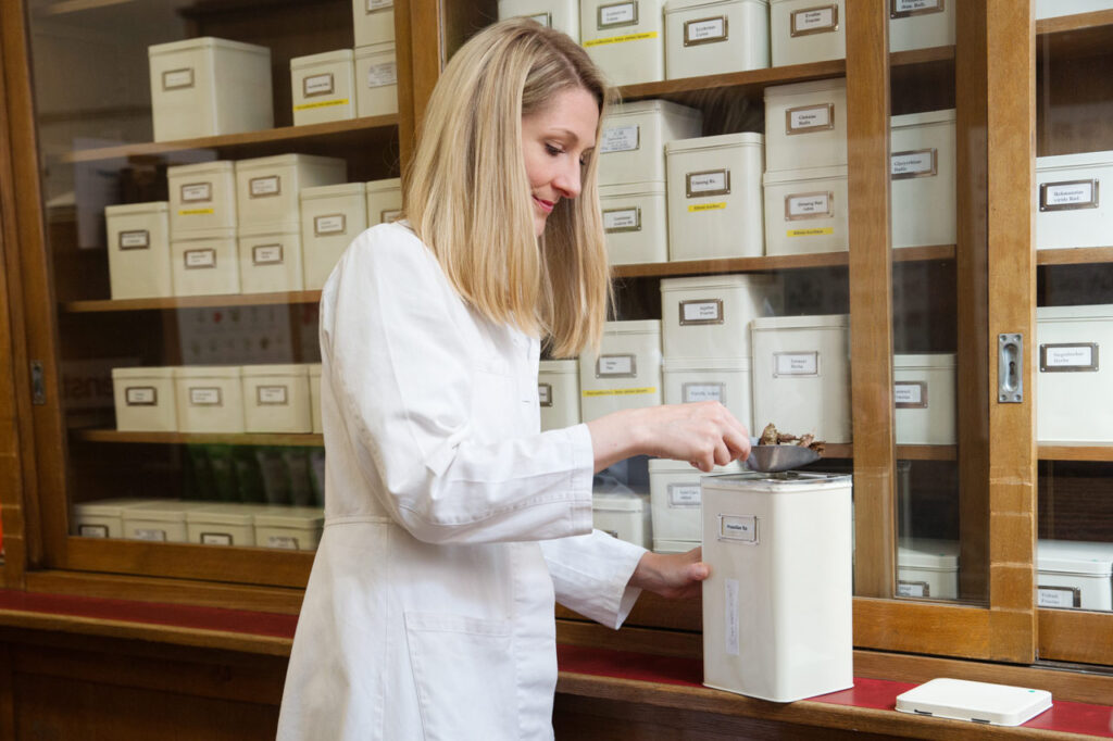 Unternehmensfotografie: Apothekerin beim Zubereiten von Kräutertee